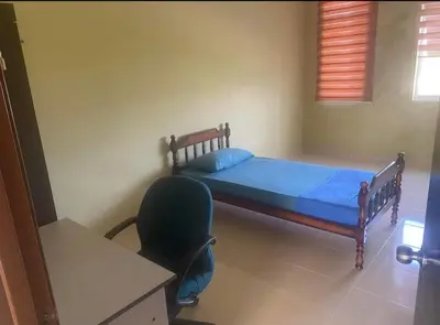 a bedroom with a bed and a desk and a chair at Jentayu homestay in Seri Iskandar