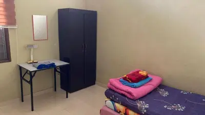 a bedroom with a bed and a table and a cabinet at Jentayu homestay in Seri Iskandar