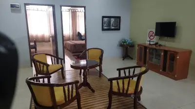 a living room with a table and chairs and a television at Jentayu homestay in Seri Iskandar
