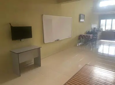 a room with a white board on a wall with a table and a podium at Jentayu homestay in Seri Iskandar