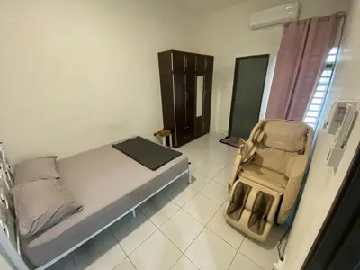 a bedroom with a bed and a stroller in it at Homestay Nafisah in Tapah Road