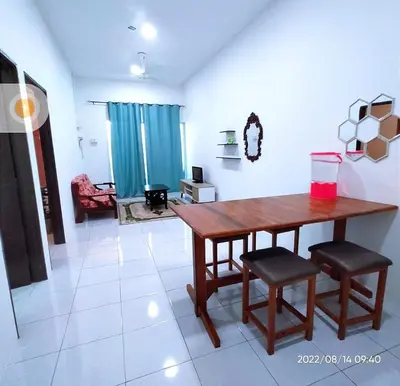 a living room with a wooden table and two chairs at Homestay Nafisah in Tapah Road