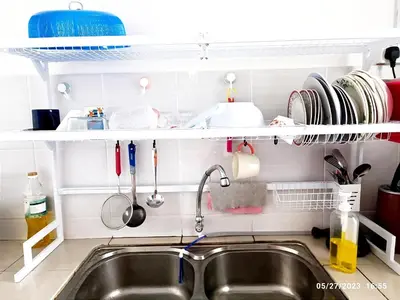 a kitchen sink with utensils and a shelf above it at Homestay Nafisah in Tapah Road