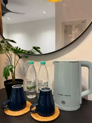 a counter with two bottles of water and a mirror at Stylish Balinimo Guest room - King Bed, Free Netflix, Prime & Wi-Fi Near Bukit Mertajam in Kubang Semang