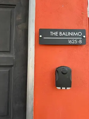 a black sign on the side of a red door at Stylish Balinimo Guest room - King Bed, Free Netflix, Prime & Wi-Fi Near Bukit Mertajam in Kubang Semang
