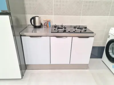 a kitchen with a counter with a stove at White Sweet Homestay, Kulim Hi-Tech Park Kedah in Kulim