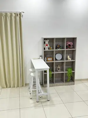 a white table and stool in a room with a curtain at HeyFam Homestay in Sekincan