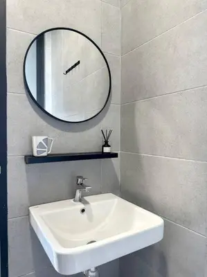 a bathroom with a sink and a mirror on the wall at Georgetown Modern Stylish Urban 3BR, InfinityPool with Seaview, 3 Queen bed in Jelutong
