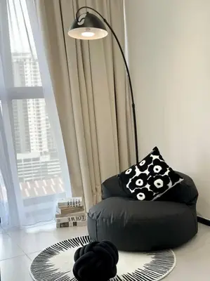 a black chair sitting in a room with a window at Georgetown Modern Stylish Urban 3BR, InfinityPool with Seaview, 3 Queen bed in Jelutong