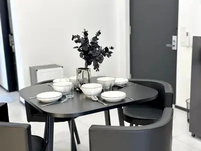 a black table with plates and bowls and a vase at Georgetown Modern Stylish Urban 3BR, InfinityPool with Seaview, 3 Queen bed in Jelutong