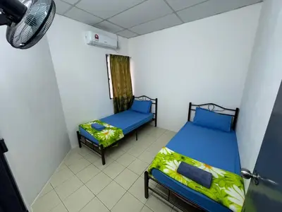 a room with two beds and a window at Homestay Cikgu Iqa (Muslim) in Kuala Kangsar