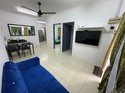 a living room with a blue couch and a table at Homestay Cikgu Iqa (Muslim) in Kuala Kangsar
