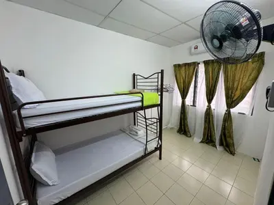 a room with two bunk beds and a fan at Homestay Cikgu Iqa (Muslim) in Kuala Kangsar