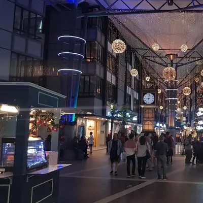 a group of people walking through a shopping mall at night at Emerald Avenue Brinchang 8 guests 3 bedrooms in Brinchang