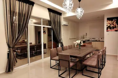 a dining room with a wooden table and chairs at Shamrock Breeze Villa: Coastal Haven for 29 Guests in Batu Ferringhi