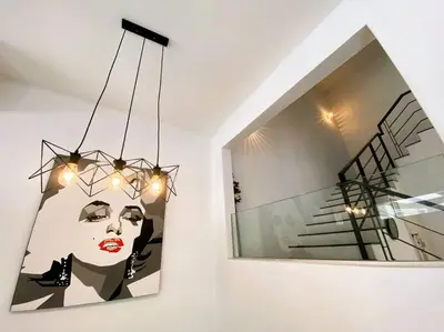a painting of a woman on a wall next to a mirror at Shamrock Breeze Villa 2: Coastal Haven for 25 Guests in Batu Ferringhi