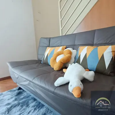 two stuffed animals sitting on a leather couch at Minimalist Duplex @ BayanLepas in Bayan Lepas
