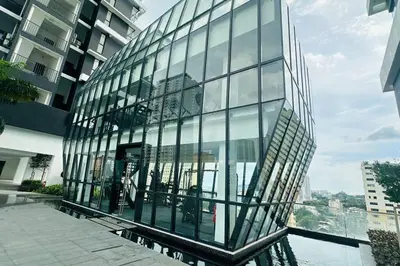a glass building with a reflection in the water at Deluxe Seaview Georgetown Penang @ ComfyLux Homestay in Jelutong