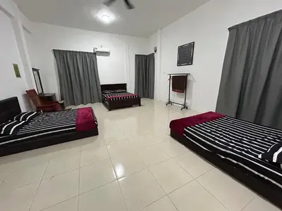 a room with two beds and a tv in it at Homestay De' Afraa Sungai Besar IslamFriendly in Sungai Besar