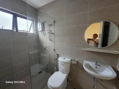 a woman taking a picture of a bathroom with a toilet and sink at Sunway Ipoh - DamaiStay - 5min to Tambun - 20Pax in Tambun