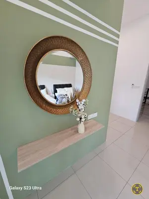 a round mirror on a wall with a vase of flowers at Sunway Ipoh - DamaiStay - 5min to Tambun - 20Pax in Tambun