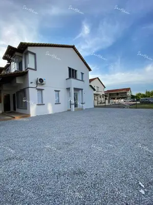 a white house with a parking lot in front of it at SmartChoice Homestay in Bukit Mertajam