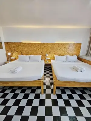 two beds in a room with a checkered floor at The 60 in George Town