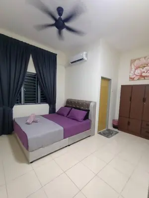a bedroom with a purple bed and a ceiling fan at D’Kayangan Homestay BBSAP Sitiawan in Sitiawan