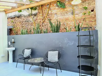 two chairs and a table in front of a wall at Stewart Hotel at 67 By EVR - Newly Renovated 2024 in George Town