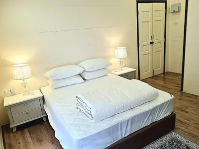 a bedroom with a bed with white sheets and pillows at Stewart Hotel at 67 By EVR - Newly Renovated 2024 in George Town