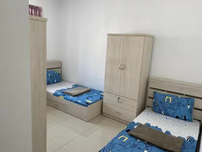 two twin beds in a room with two cabinets at Meadow Park (1331 Sweet Home) in Kampong Malim Nawar