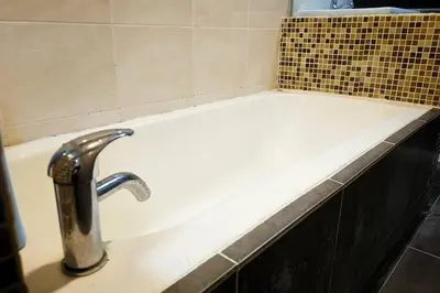 a bath tub with a faucet in a bathroom at Laguna 1, Marina Island by TZ Homestay in Lumut