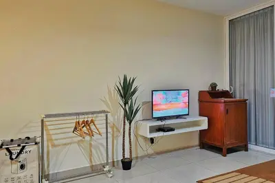 a living room with a tv on a desk with a plant at Laguna 1, Marina Island by TZ Homestay in Lumut