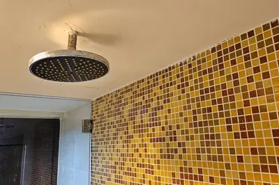 a bathroom with a yellow and brown tiled wall at Laguna 1, Marina Island by TZ Homestay in Lumut