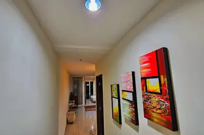 a hallway with paintings hanging on a wall at Laguna 1, Marina Island by TZ Homestay in Lumut