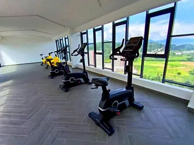 a gym with treadmills and exercise bikes and windows at The Horizon Ipoh Dual L13 by Grab A Stay in Ipoh