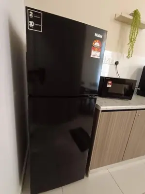 a black refrigerator in a kitchen next to a counter at The Horizon Ipoh Dual L13 by Grab A Stay in Ipoh