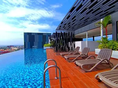 a row of chaise lounge chairs next to a swimming pool at The Horizon Ipoh Dual L13 by Grab A Stay in Ipoh