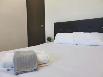 a bedroom with a white bed with towels on it at White House 19 Room A in Bukit Mertajam