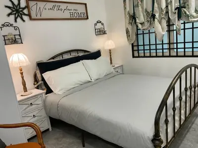 a bedroom with a bed and a sign on the wall at Jessie Home in Bukit Mertajam