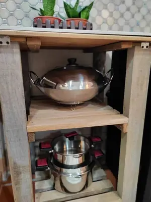 a wooden shelf with a copper bowl and pans on it at Jessie Home in Bukit Mertajam