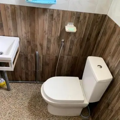 a bathroom with a white toilet and a sink at Chalet Naqib in Gerik