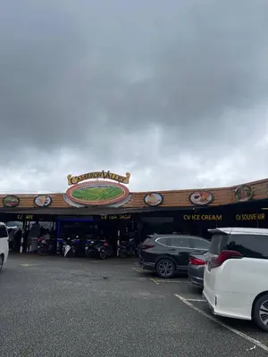 a building with cars parked in a parking lot at ROYAL LILY TANAH RATA BY JUNIKASTAY in Tanah Rata