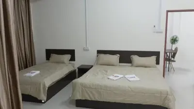 a bedroom with two beds and a mirror at Happy homestay in Teluk Intan