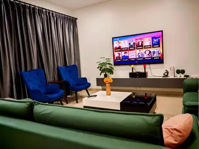 a living room with a green couch and blue chairs at Ipoh Urban Retreat 20PAX 5 Room Holiday Villa by City Home Empire in Ipoh