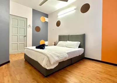 a bedroom with a bed with a black cat sitting on it at Ipoh IGB Homestay by Comfort Home in Ipoh