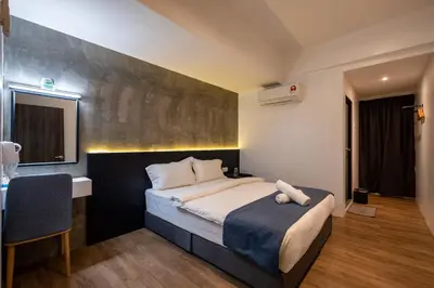 a bedroom with a bed and a table and a desk at Boutique Hidden loft in Bukit Mertajam