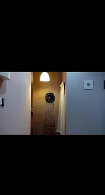 a hallway with a clock in the corner of a room at De'Lakeside musslim's homestay in Raub