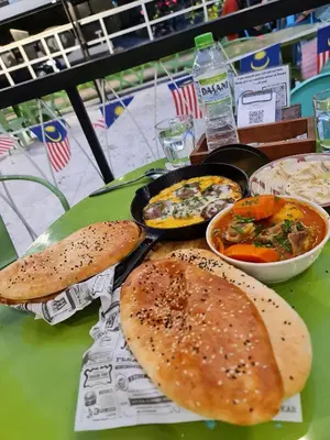 a table topped with bread and bowls of food at Cheerful Guesthouse #Adventist#BudgetStay in George Town