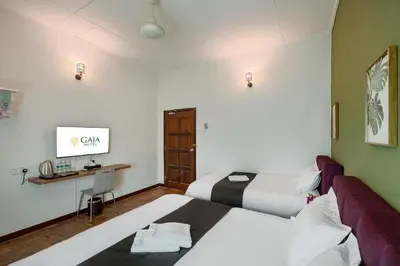 a hotel room with two beds and a desk at GAIA Hotel in Tanjung Bungah
